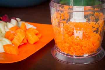 Carrots for borsch in an electric chopper. Soup cooking.