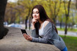 © Vadym - Young pretty stylish woman talking on smart phone in the city park