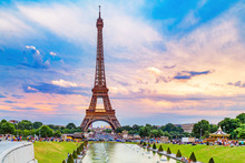 Eiffel Tower, View From Trocadero Park Over Fountain. People Making Their Evening Promenade Around Fountain. Eiffel Tower Is Famous Symbol Of Paris City And France. Sunset Scenery, Epic Dramatic Sky.