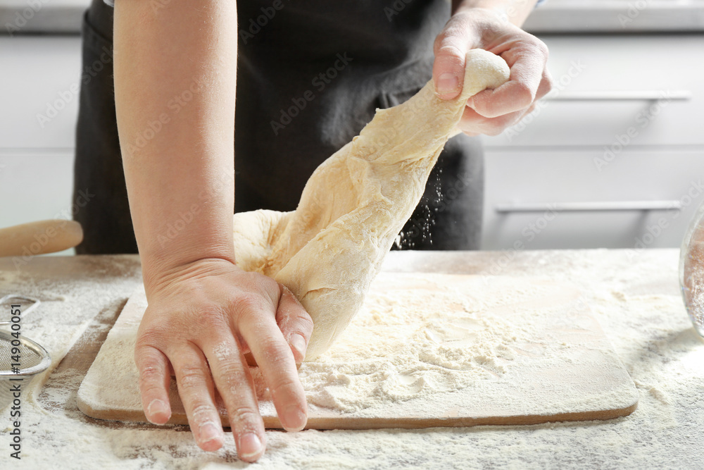 Chef kneading dough in kitchen, closeup