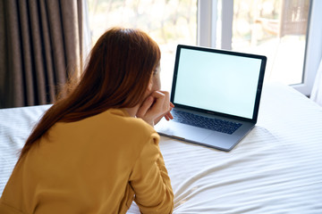 woman on the bed looking at laptop