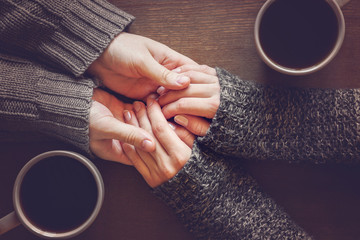 man holding woman's hands. young couple enjoying coffee and lovely conversations in the romantic eve