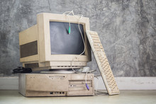 Old And Obsolete Computer Set On The Floor With Grunge Concrete Wall Background, Vintage Color Tone
