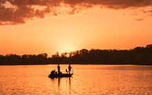 People Are Boating And Fishing Under Sunset