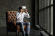 Man wearing virtual reality goggles watching movies or playing video games. The vr headset design is generic and no logos