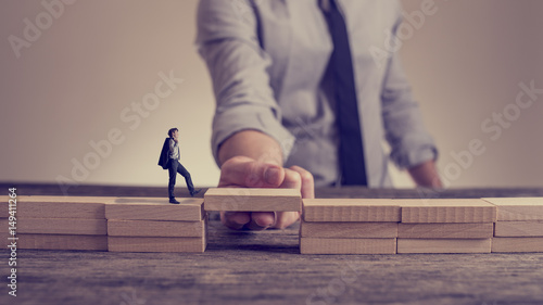 Fotografía Man solving problems by building bridge with wooden block
