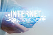 © Production Perig - Concept of man holding futuristic interface with internet title and multimedia icons flying all around - Internet concept