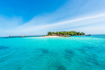 colorful seascape with african island on the horizon with turquoise ocean and blue sky