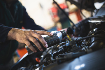 Close up hands of unrecognizable mechanic doing car service and maintenance. Oil and fuel filter changing.