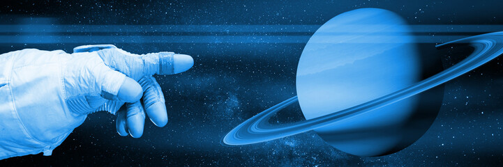Wall Mural - astronaut pointing to planet saturn