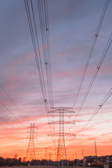 Wall Mural - Group silhouette of transmission towers (or power tower, electricity pylon, steel lattice tower) at bloody red sunset in Humble, Texas, US. Texture of high voltage pillar, overhead power lines at dusk