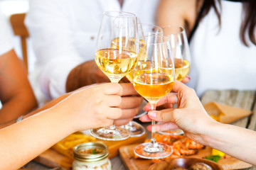 Wall Mural - Hands with red wine toasting over served table with food.