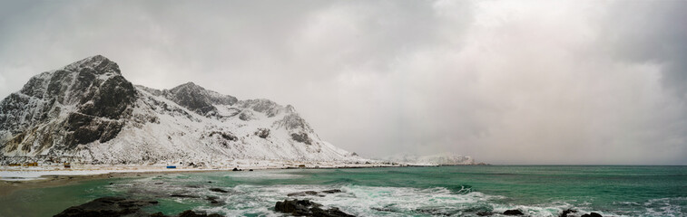 Poster - Sunrise on the stone shore of the ocean and mountains with snow on the horizon