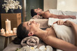 canvas print picture - Man and woman lying down on massage beds at Asian wellness center