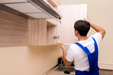 Young man assembling kitchen furniture