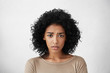 © wayhome.studio  - Beautiful young dark-skinned woman wearing beige top frowning looking at camera, having clueless facial expression, feeling confused about talk with her boyfriend. Life perception and attitude