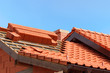 roof under construction with stacks of red ceramic roof tiles ready to fasten