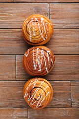 Wall Mural - Cinnamon buns on brown wooden table