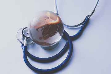 global healthcare. globe and stethoscope, studio shot.blue toned images