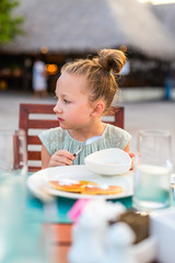 Wall Mural - Little girl eating breakfast