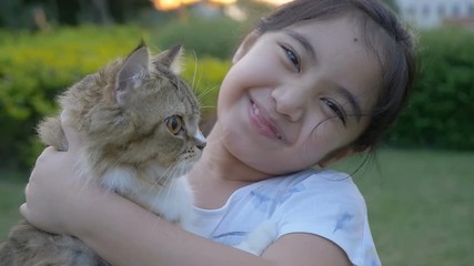 Wall Mural - Slow motion of lovely Asian girl plays with her Persian cat in the park