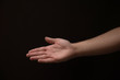 © haoka - Open male hand coming out of the right side of the frame, on a black background
