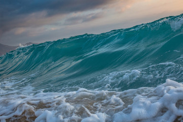 Fototapete - Sea wave rising. Ocean shorebreak at sunset time.