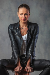 Sticker - relaxed sexy woman in leather clothes sitting on stool