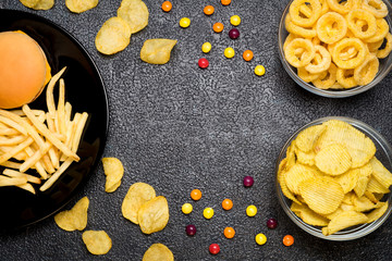 Wall Mural - Fast food: top view of burger, french fries, chips, rings and candies. Unhealthy eating concept