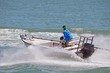 Small sport fishing skiff powered by a single outboard engine speeding on the florida intra-coastal waterway .