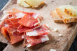 Spanish ham jamon serrano or Italian prosciutto crudo and sliced Italian hard cheese pecorino toscano on old wooden board