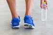 © shark749 - Man wearing sport shoes and picking up water bottle in gym, sport exercise concept