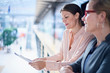 © Connect Images - Two businesswomen reading paperwork on office balcony
