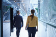 © Connect Images - Rear view of businesswoman and man walking through office atrium