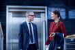 © Connect Images - Businesswoman and man walking and talking on office balcony