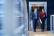 © Connect Images - Businesswoman and man walking and talking on office balcony