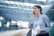 © Connect Images - Businesswoman making smartphone call on office balcony