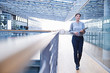 © Connect Images - Businesswoman walking along office balcony