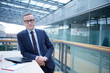 © Connect Images - Portrait of businessman leaning against office balcony table