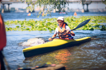 Wall Mural - Young people are kayaking on a river in beautiful nature.