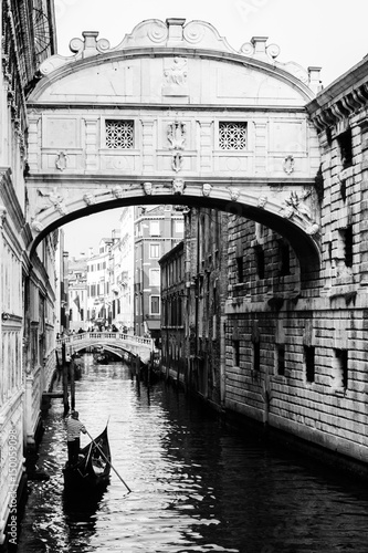 Naklejka na drzwi Ponte dei sospiri with a gondola floating towards it. Venice, Italy. Black and white.