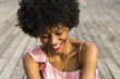 close up portrait of  a Happy young beautiful afro american woman sitting on wood floor and smiling. Spring or summer season. Casual