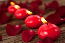Red Wax Candles Surrounded With Rose Petals