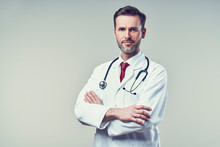 Portrait Of Handsome Doctor Standing With Crossed Arms. Isolated