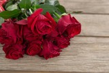 Fototapeta Kwiaty - Bunch of red roses on wooden background