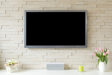 Blank Modern Flat Screen TV At The White Brick Wall With Copy Space