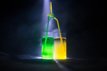 bright yellow green cocktail garnished with lime. Classic alcohol cocktails, alcoholic drinks, soft drinks, tasty cocktails on dark background with smoke and light