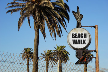 Wall Mural - aged and worn vintage photo of beach walk sign with palm trees