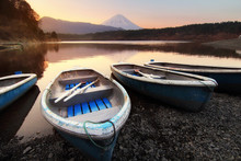 Beautiful Scenery During Sunrise Of Lake Saiko In Japan With The Rowboat Parked On The Waterfront And Mountain Fuji Background. Travel And Attraction Concept