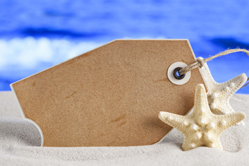 Wall Mural - Blank paper label and starfish on beach sand and sea background